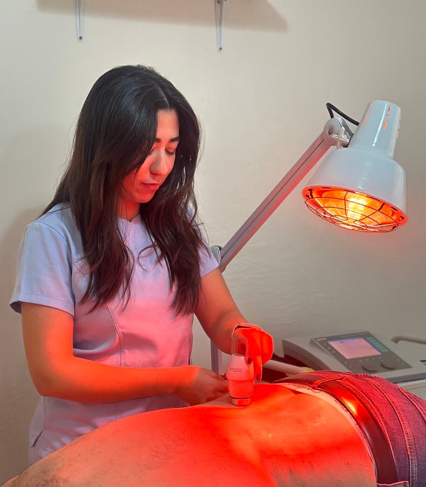 Kinésithérapeute traitant un patient sous lampe infrarouge